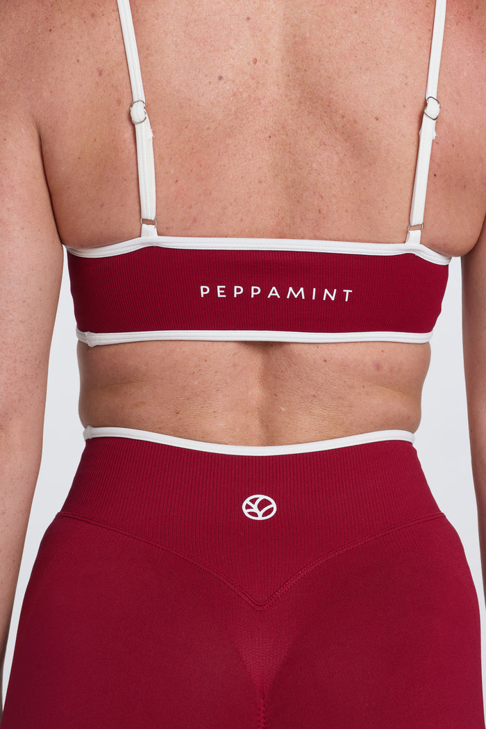Seamless gym bra, with luxe white trim and adjustable back straps in wine colour.