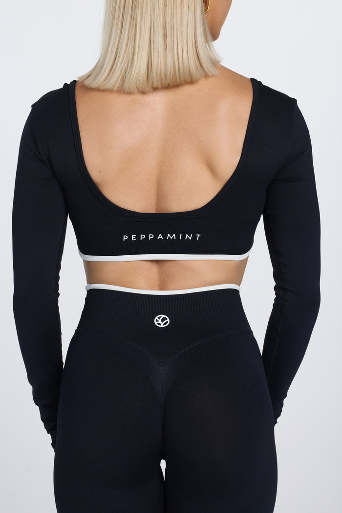 Long sleeve seamless crop top, with built in white contrasting bra, luxe white trim, and adjustable halter strap in black colour.