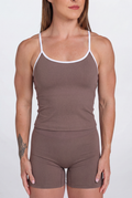 Woman wearing a Mocha tank top and shorts set with white trim on a white background