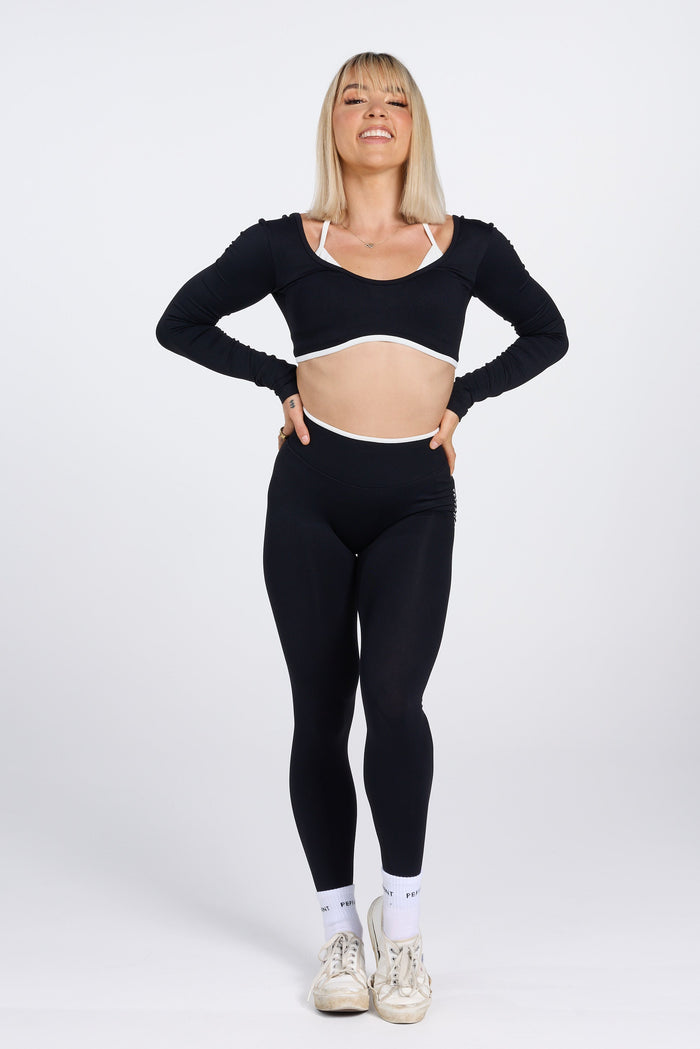 Long sleeve seamless crop top, with built in white contrasting bra, luxe white trim, and adjustable halter strap in black colour.