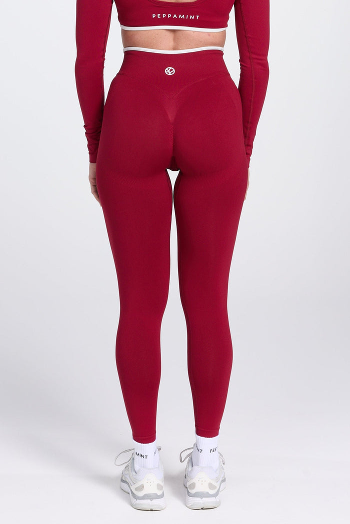 High waisted seamless gym tights, with textured booty sculpting panels, and a luxe white trim, in wine colour.