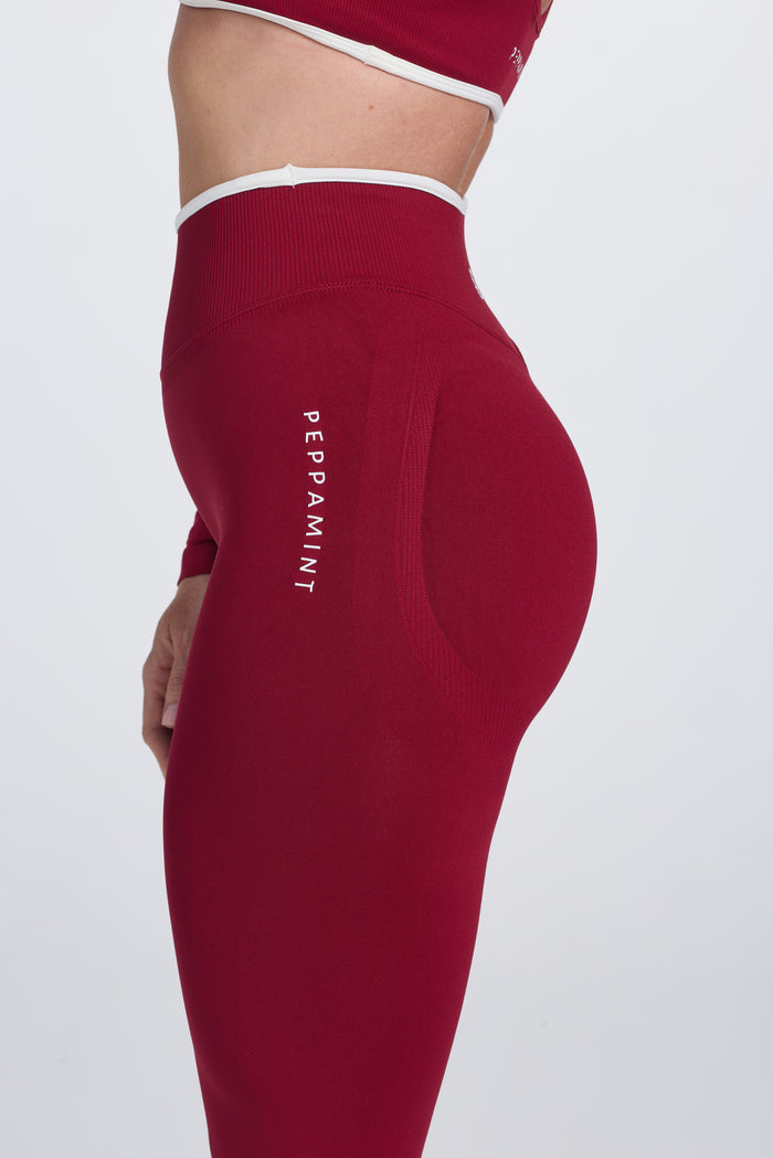 High waisted seamless gym tights, with textured booty sculpting panels, and a luxe white trim, in wine colour.