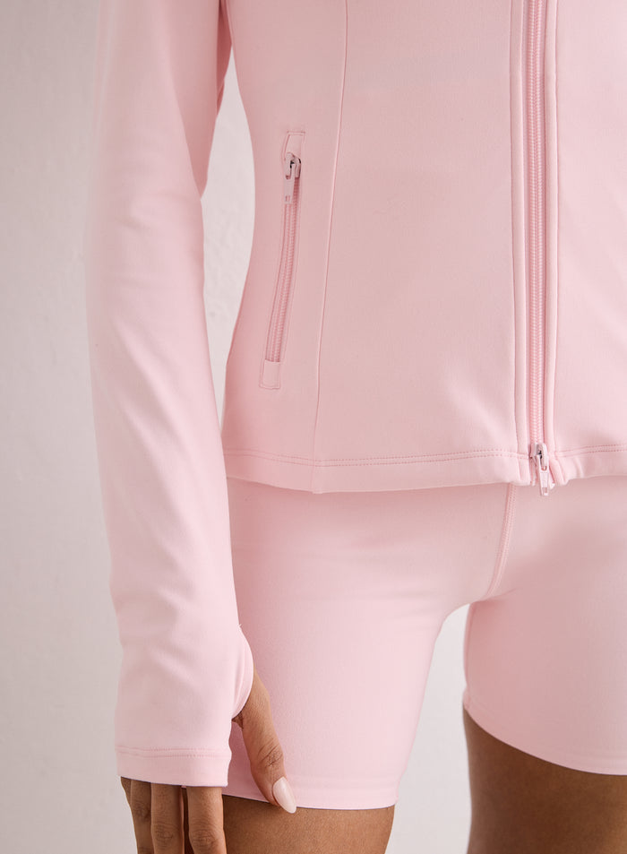 Lähikuva vaaleanpunaisesta Sense Zip Jacket -takista, jossa on kaksisuuntainen vetoketju ja peukalonreiät [XS-170cm]