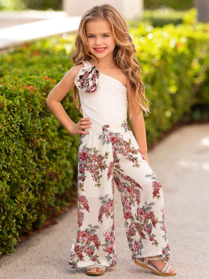 Girl wearing a one-shoulder floral pants set from the spring collection by Mia Belle Girls