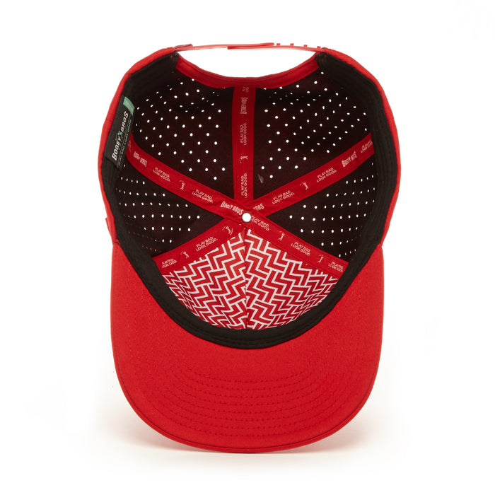 The Bogeyman Red Performance Golf Hat - Snapback is shown from above, revealing its black interior panels with white ventilation holes, red logo strips, and a geometric white zigzag pattern on the brim.