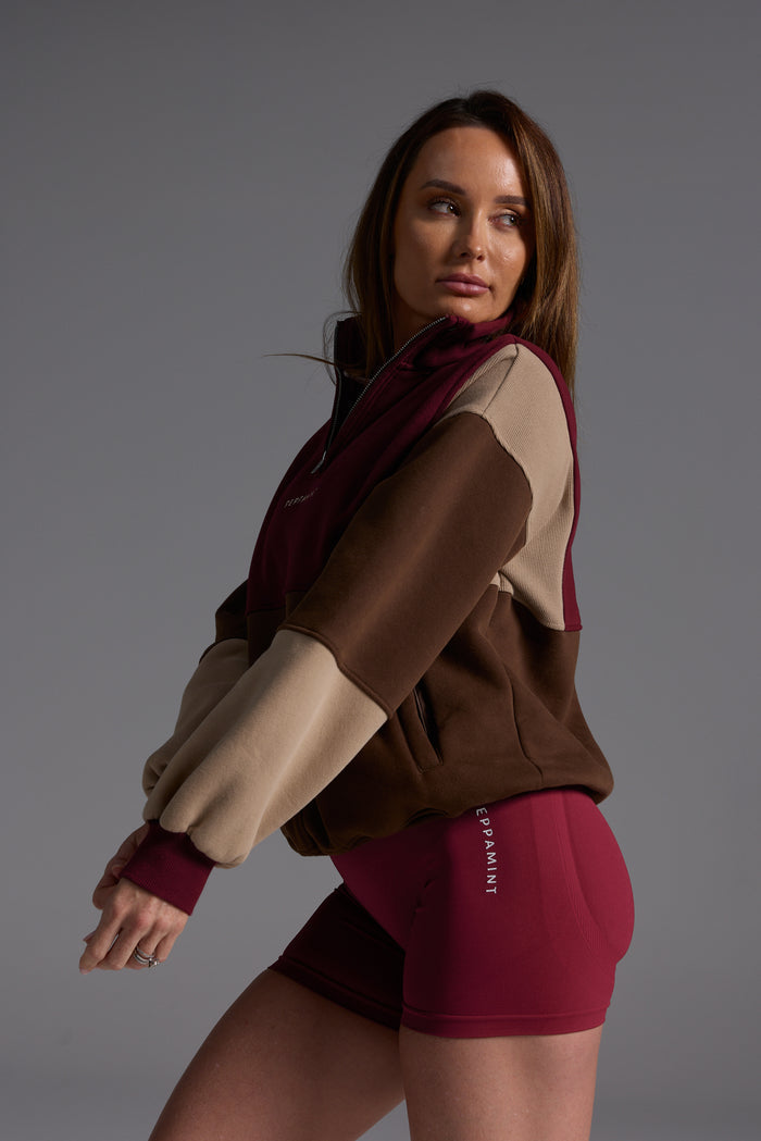 1/4 zip fleece jumper with double collar, ribbed stretchy fabric panel inserts, and two convenient zip pockets in a wine, chocolate and beige colour block design.