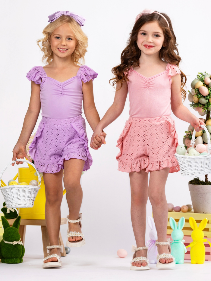 Little girl in coral ruffle sleeve top and eyelet shorts set for warm weather