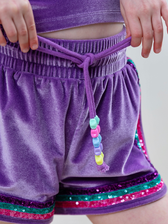 Girl wearing sparkly mermaid outfit with colorful trim and soft velour