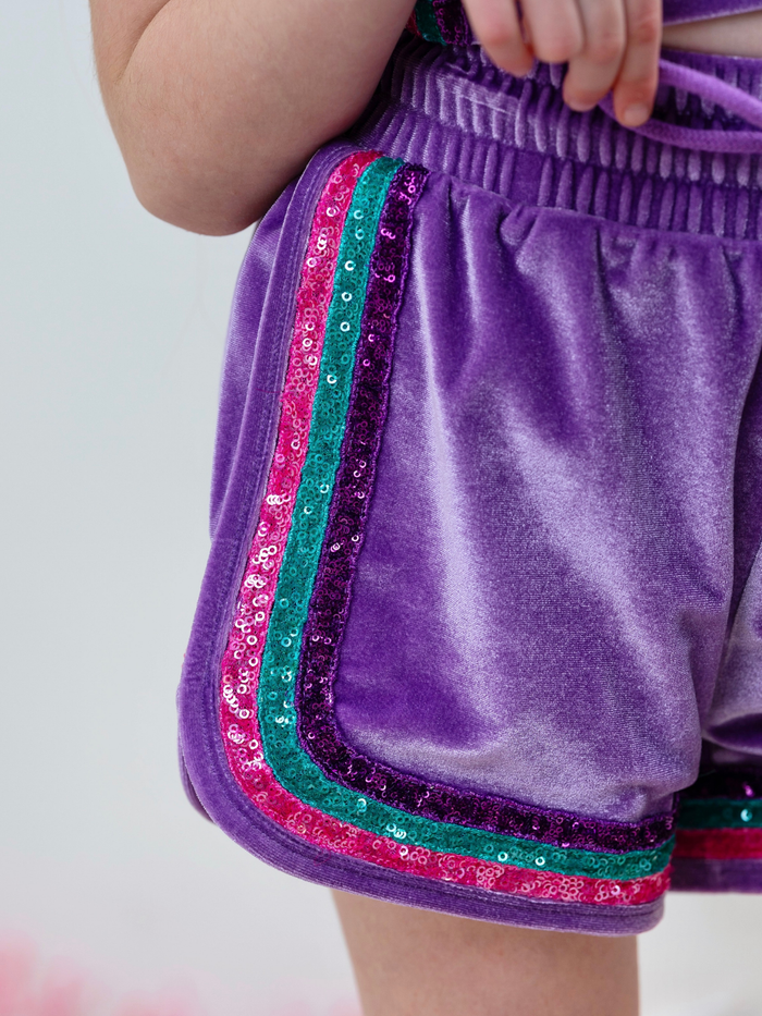 Girl wearing mermaid sparkle short set with colorful glitter details