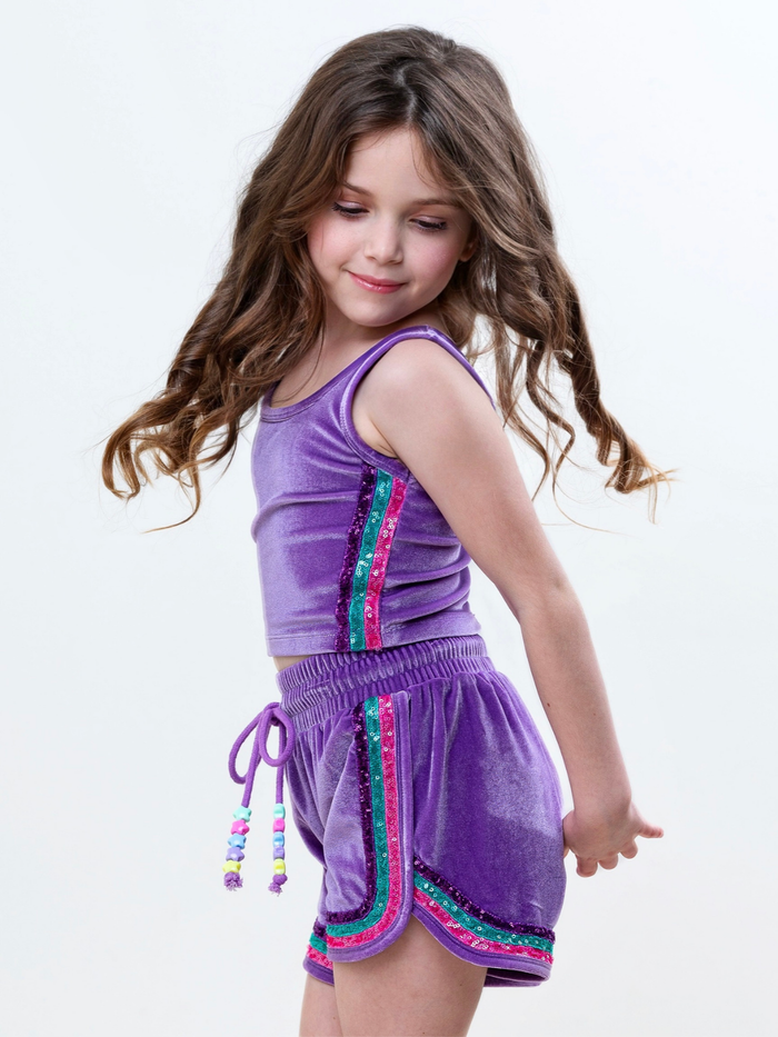 Girl wearing mermaid inspired purple velour short set with sparkle trim