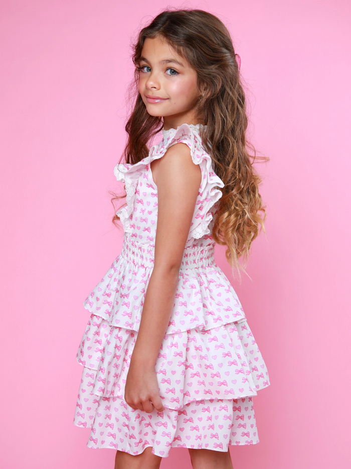 Stylish girls white dress with pink bows, hearts, and smocked waist