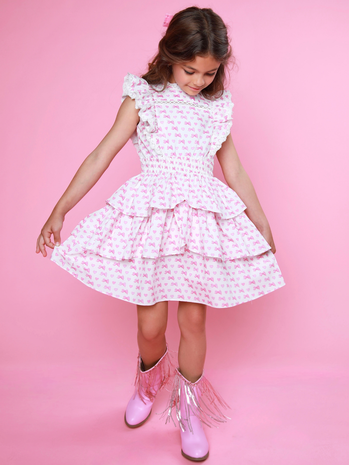 Stylish girls white dress with pink bows, hearts, and smocked waist