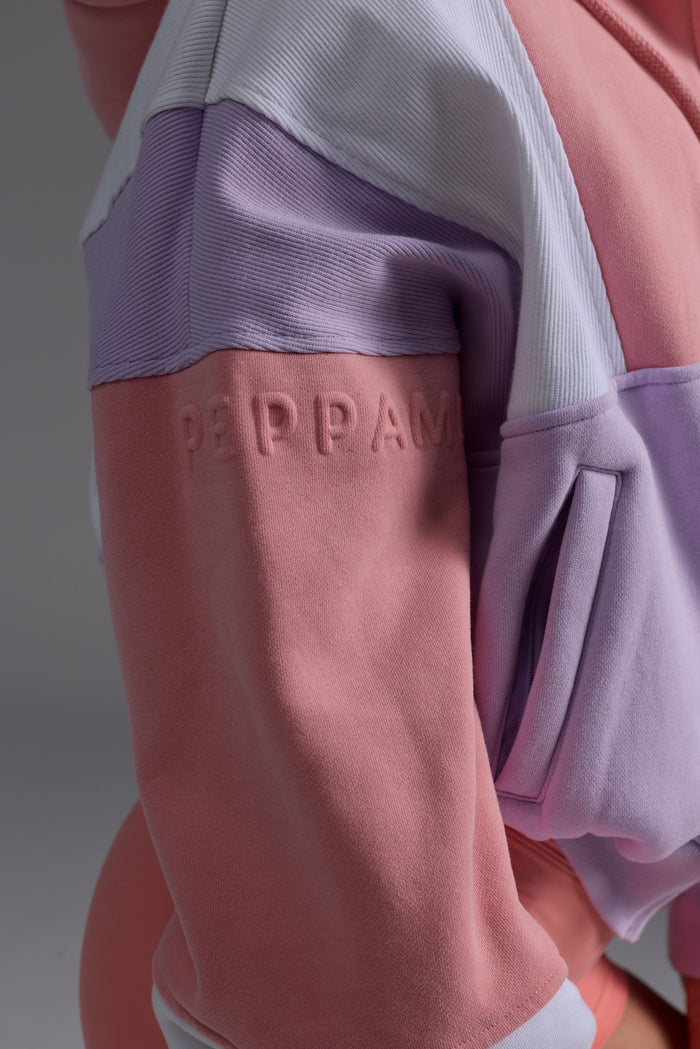 Detail shot of peach, lilac and white fleece hoodie fabric and colour blocking design