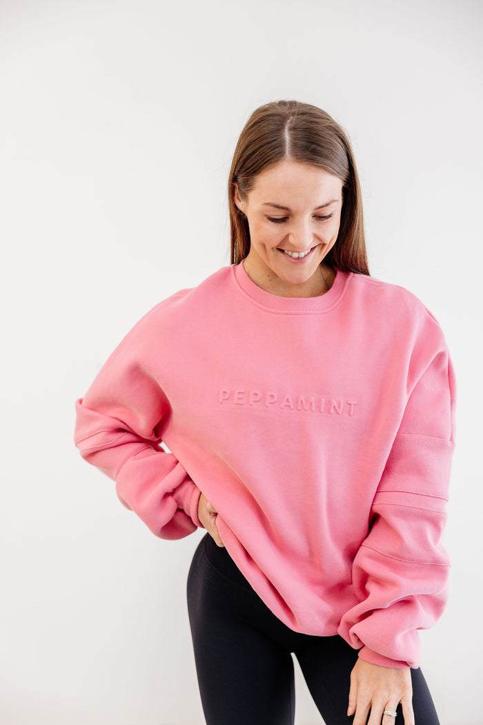 peony pink crew neck jumper with ribbed arm panels in pink with embossed logo breast cancer awareness