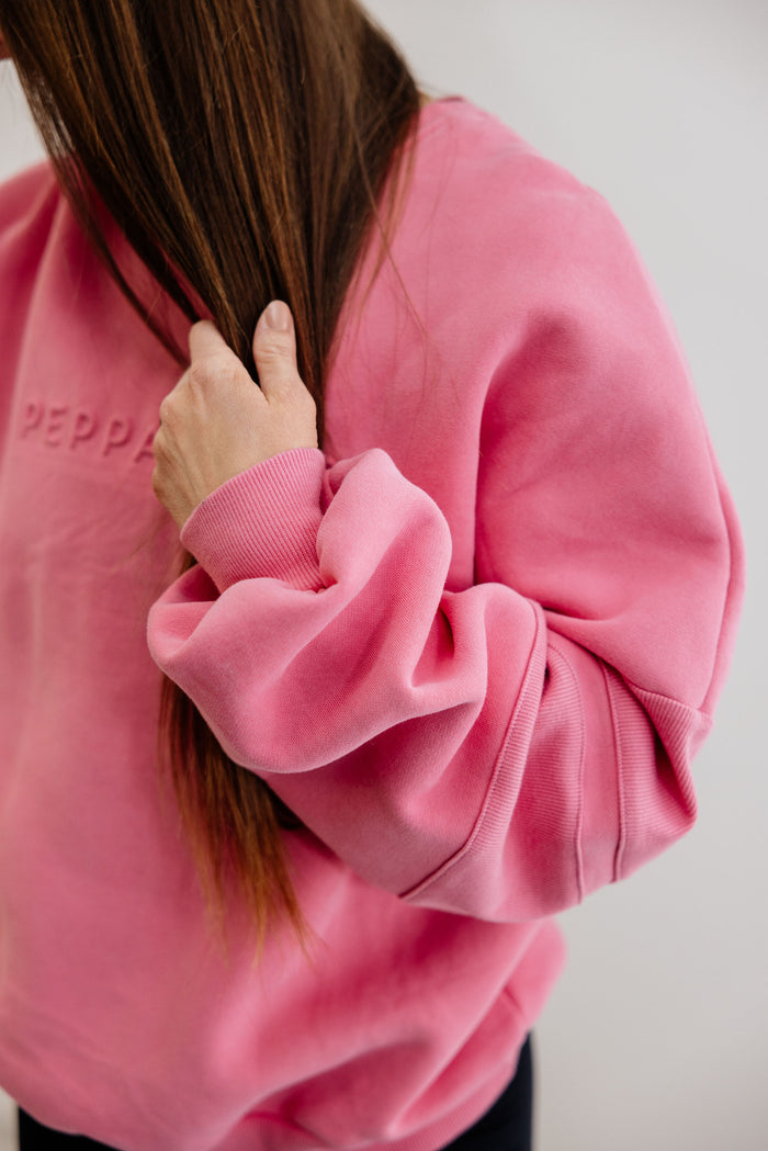 peony pink crew neck jumper with ribbed arm panels in pink with embossed logo breast cancer awareness