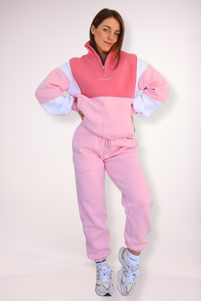 1/4 zip fleece jumper with double collar, in peony pink/white and baby pink colour panels, with feature panels ribbed stretchy fabric inserts, and two convenient zip pockets paired with fleece lined joggers with elasticated waistband, drawstring and embossed logo icon on pocket