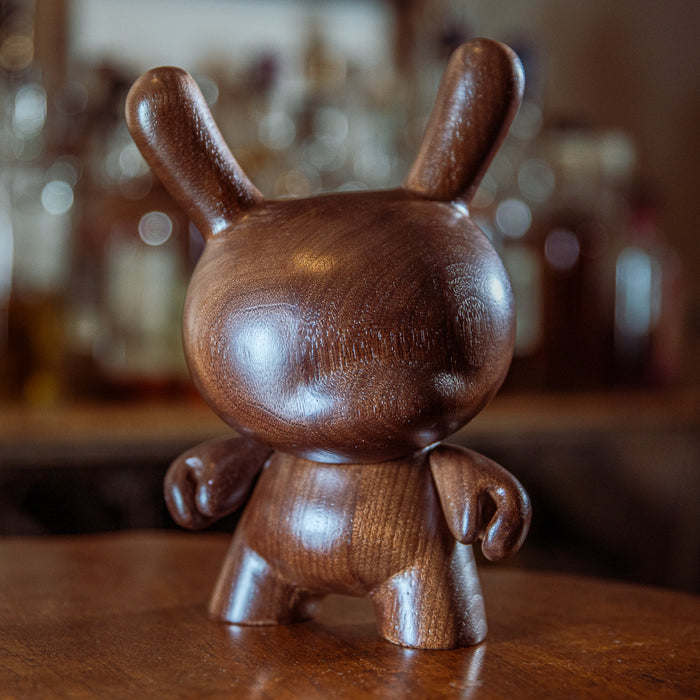Limited edition Kidrobot RAW 8-inch black walnut wood Dunny figure with detailed dark wood finish and intricate sculpting.