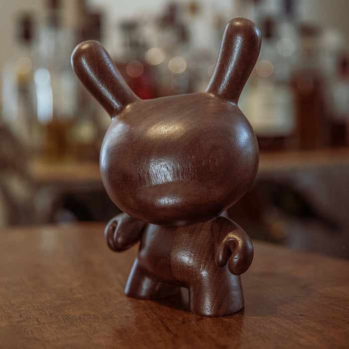 Kidrobot RAW 8-inch Black Walnut Wood Dunny, limited edition collectible figure with dark wood finish, shown from front view.