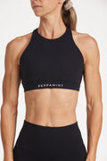 Buttery soft high waisted women's gym shorts with 4" inseam with curved stitched detailing for a butt shaping effect, and no front rise seam, paired with a high neck women's sports bra with a supportive elasticated hem and triple layered fabric with removable pads for extra support and crossover back straps in Black.