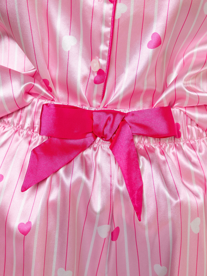 Little girl and mom wearing matching pink satin pajama shorts set with heart print