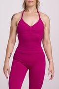 Halter neck tank top with breast contouring panels and a ruched front seam, a built in bra, and an open upper back design and seamless gym tights with booty contouring panels, invisible scrunch technology, sweetheart shaped back seams and thick supportive fabrics in magenta