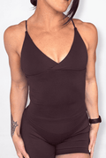 A woman wearing a dark brown athletic tank top with a V-neckline and matching shorts, shown against a plain light background.