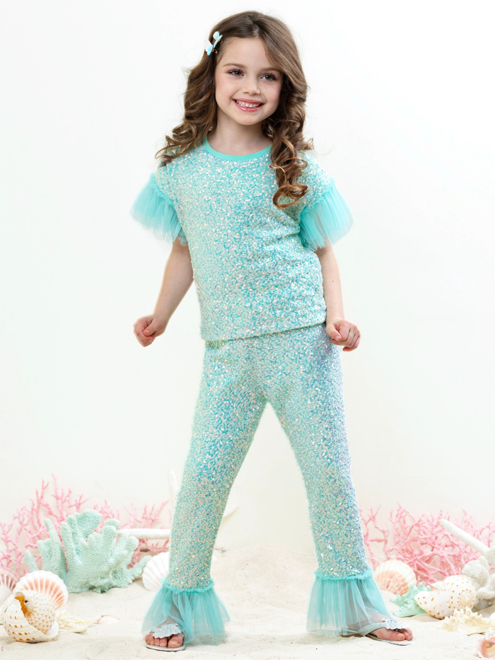 Girl wearing seafoam sparkle pant set with ruffle sleeves and tulle details