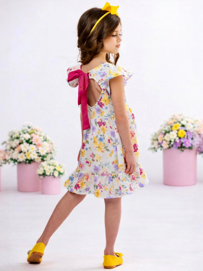 Girl wearing floral spring dress with ruffle hem and flutter sleeves