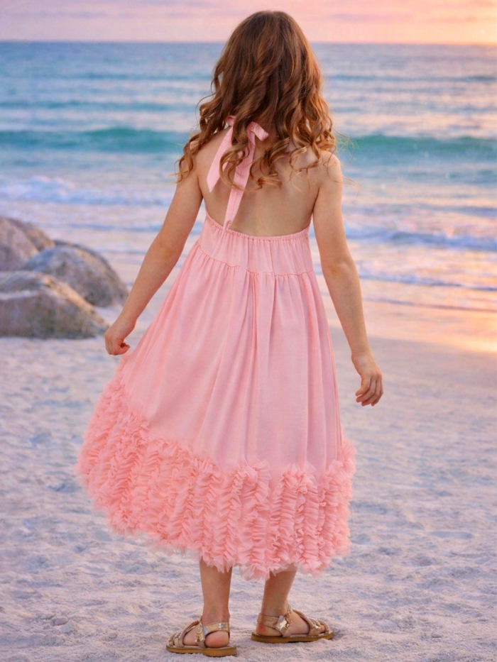 Girl wearing flowy coral dress with high low hem and ruffle layers