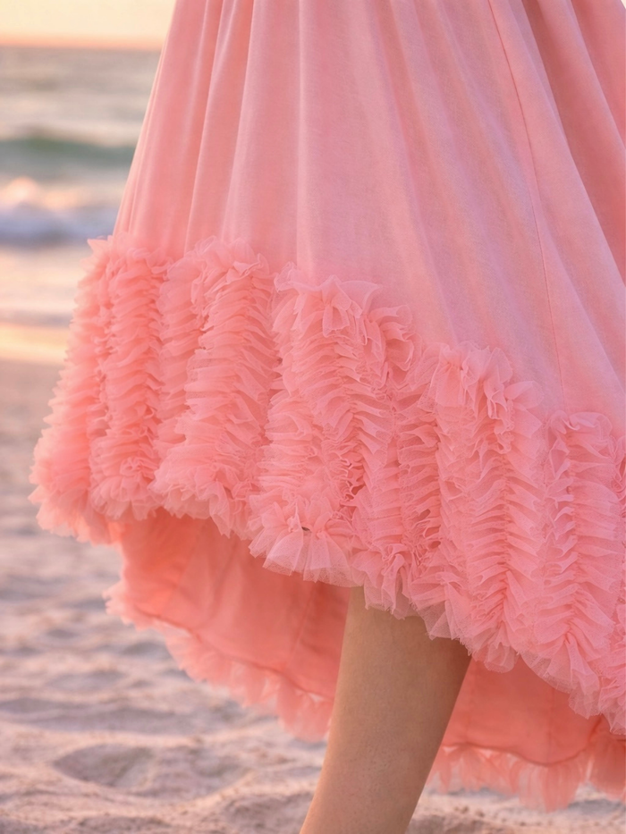 Girl wearing elegant coral dress with layered ruffle detail