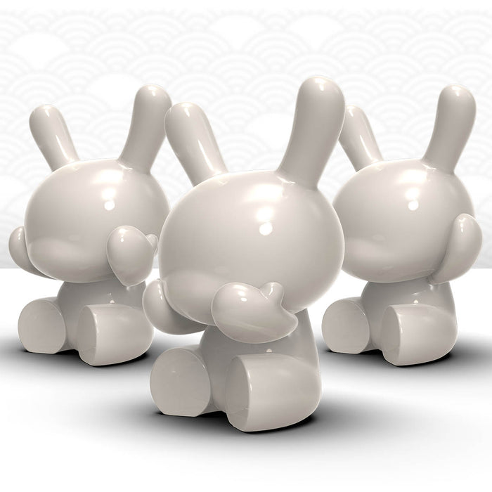 Three white and gold Kidrobot Dunny porcelain figures from the Three Wise Dunnys 5-inch 3-pack, limited edition of 500.